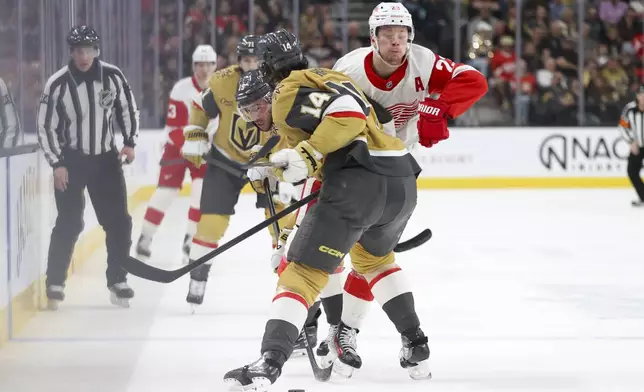 Detroit Red Wings left wing Lucas Raymond (23) collides with Vegas Golden Knights defenseman Nicolas Hague (14) during the first period of an NHL hockey game Saturday, March 22, 2025, in Las Vegas. (AP Photo/Ian Maule)