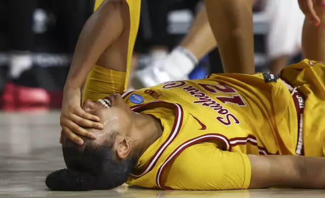 Southern California guard JuJu Watkins (12) reacts on the floor after an injury during the first half against Mississippi State in the second round of the NCAA college basketball tournament Monday, March 24, 2025, in Los Angeles. (AP Photo/Jessie Alcheh)