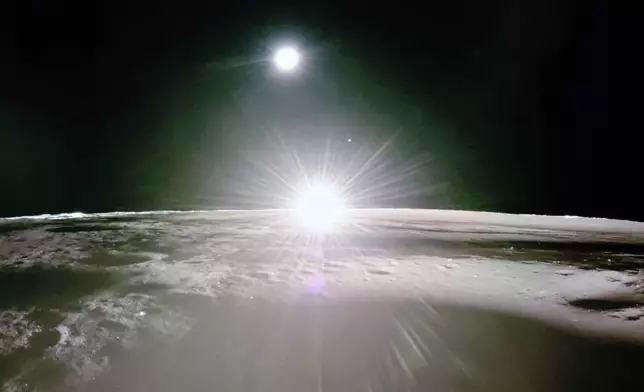 This image provided by NASA/Firefly Aerospace, Tuesday, March 18, 2025, shows the sun setting on the moon, with Earth and Venus in the distance. (NASA/Firefly Aerospace via AP)