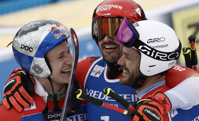 Switzerland's Loic Meillard, center, winner of an alpine ski, men's World Cup Giant Slalom, celebrates with second-placed Switzerland's Marco Odermatt, left, and third-placed Switzerland's Thomas Tumler, in Hafjell, Norway, Saturday, March 15, 2025. (AP Photo/Gabriele Facciotti)