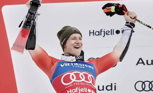 Switzerland's Marco Odermatt celebrates on the podium after taking second place in an alpine ski, men's World Cup Giant Slalom, in Hafjell, Norway, Saturday, March 15, 2025. (AP Photo/Gabriele Facciotti)