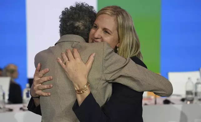 Kirsty Coventry, right, is embraced by Anita Defrantz after she was announced as the new IOC President at the International Olympic Committee 144th session in Costa Navarino, western Greece, Thursday, March 20, 2025. (AP Photo/Thanassis Stavrakis)