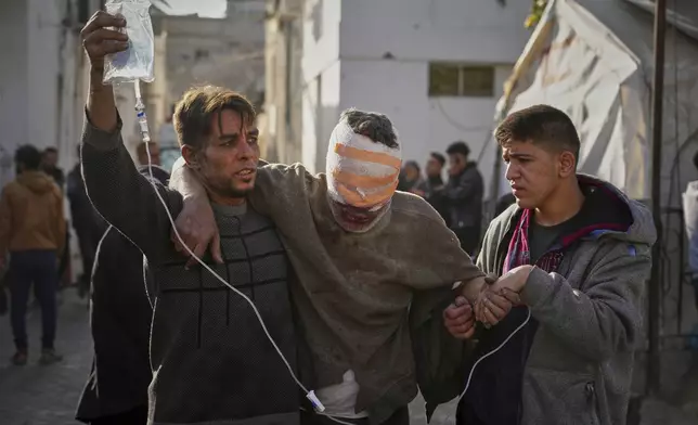 An injured man is take to the Al-Ahli hospital following Israeli army overnight airstrikes across the Gaza Strip, in Gaza City, Tuesday, March 18, 2025. (AP Photo/Jehad Alshrafi).