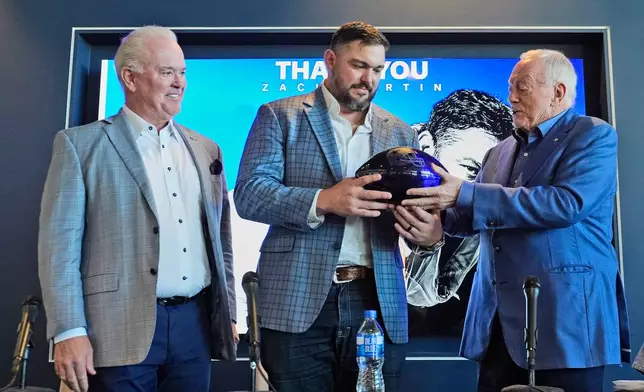 Dallas Cowboys owner Jerry Jones, right, presents lineman Zach Martin, center, with a gift as Stephen Jones looks on after Martin announced his retirement during an NFL football press conference at the team's headquarter in Frisco, Texas, Wednesday, March 5, 2025. (AP Photo/LM Otero)