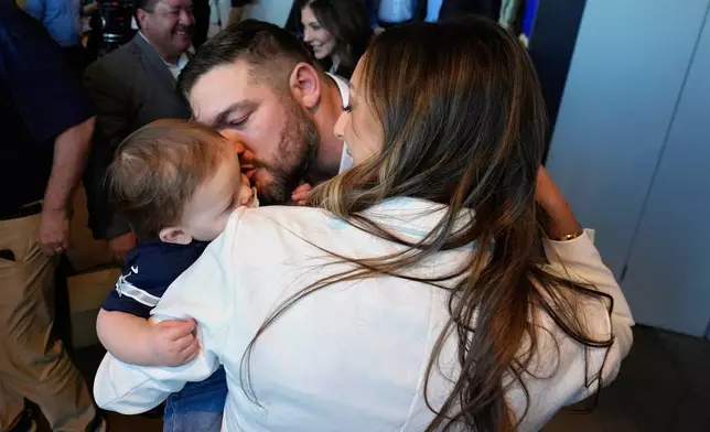 Dallas Cowboys lineman Zach Martin, center, kisses his son Hudson Gage with his wife Morgan Eifert-Martin after announcing his retirement during an NFL football press conference at the team's headquarter in Frisco, Texas, Wednesday, March 5, 2025. (AP Photo/LM Otero)