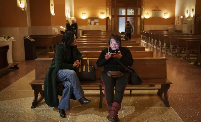 Transgenders Carla Segovia, left, and Minerva sit inside Beata Vergine Immacolata parish church in Torvaianica, Italy, Thursday, Feb. 27, 2025. (AP Photo/Bernat Armangue)