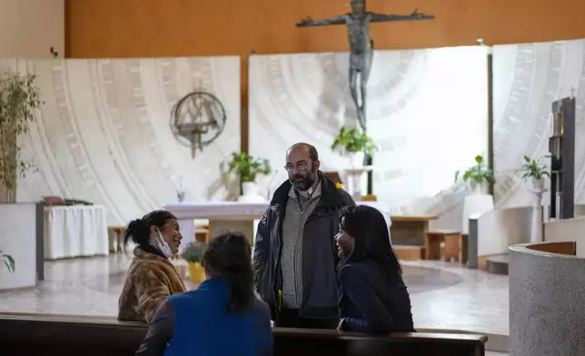 FILE - Priest Andrea Conocchia, third from left, speaks with transgender women, from left, Andrea Paola Torres Lopez from Colombia, also known as Consuelo, Claudia Vittoria Salas from Argentina and Carla Segovia from Argentina as they sit in the Beata Vergine Immacolata parish church in Torvaianica, Italy, Thursday, Nov. 16, 2023. (AP Photo/Andrew Medichini, File)