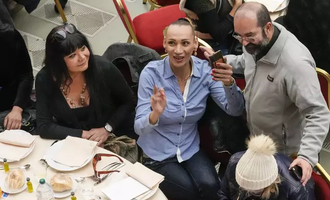 FILE- Priest Andrea Conocchia, right, with members of a group of transgender women he accompanied at a lunch for the poor with Pope Francis, in the Paul VI Hall at the Vatican, Sunday, Nov. 19, 2023. (AP Photo/Andrew Medichini, File)