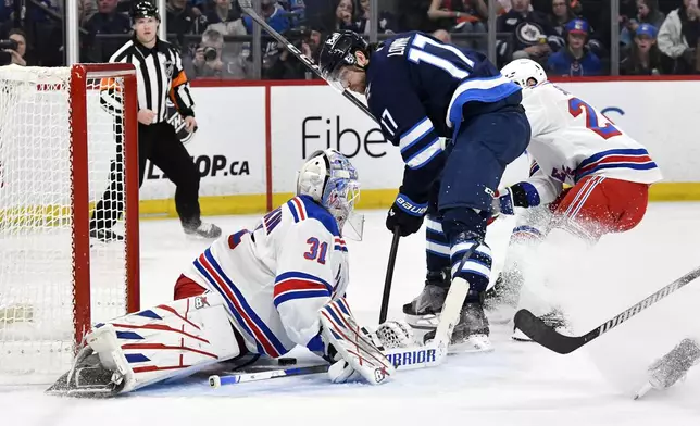 New York Rangers goaltender Igor Shesterkin (31) makes a save on Winnipeg Jets' Adam Lowry (17) during the second period of their NHL hockey game in Winnipeg, Manitoba, Tuesday, March 11, 2025. (Fred Greenslade/The Canadian Press via AP)