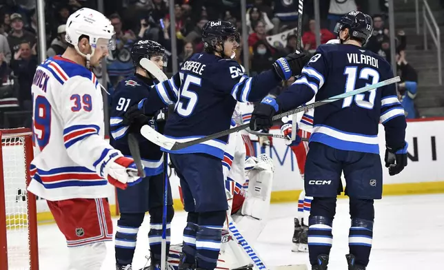 Winnipeg Jets' Gabriel Vilardi (13) celebrates his goal against the New York Rangers with Mark Scheifele (55) and Cole Perfetti (91) during the second period of their NHL hockey game in Winnipeg, Manitoba, Tuesday, March 11, 2025. (Fred Greenslade/The Canadian Press via AP)
