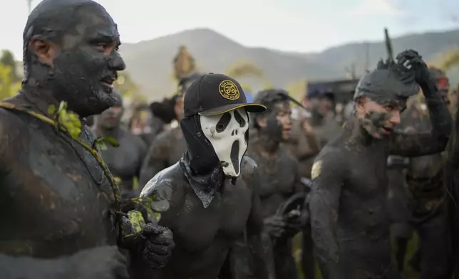 Revelers attend the Mud Block carnival party in Paraty, Brazil, Saturday, March 1, 2025. (AP Photo/Andre Penner)