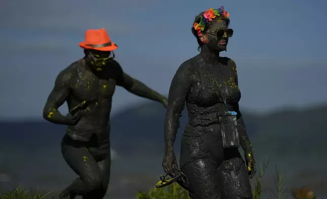 Revelers attend the Mud Block carnival party in Paraty, Brazil, Saturday, March 1, 2025. (AP Photo/Andre Penner)