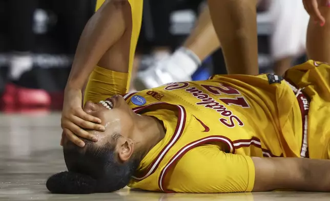 Southern California guard JuJu Watkins (12) reacts on the floor after an injury during the first half against Mississippi State in the second round of the NCAA college basketball tournament Monday, March 24, 2025, in Los Angeles. (AP Photo/Jessie Alcheh)