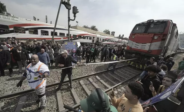 Egyptian wrestler Ashraf Mahrous, front left, better known as Kabonga, prepares to pull a train for nearly 10 meters, 33 feet, at Ramses Station in Cairo, Egypt, Thursday, March 13, 2025. (AP Photo/Amr Nabil)