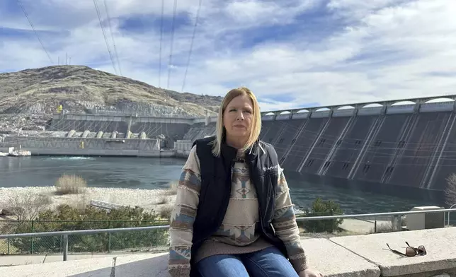 Former Grand Coulee Dam worker, Stephanie Duclos, sits in front of the Grand Coulee Dam on Friday, Feb. 28, 2025 in Coulee Dam, Wash., explaining how she was terminated from her job under the Trump administration’s federal workforce reduction plan. (AP Photo/Martha Bellisle)
