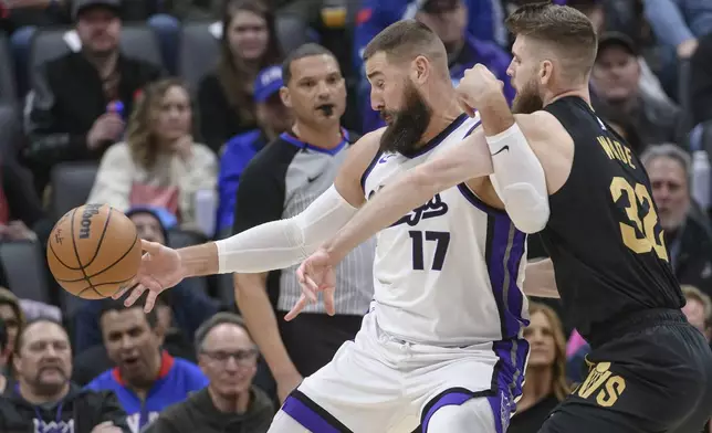 Sacramento Kings center Jonas Valanciunas (17) is guarded by Cleveland Cavaliers forward Dean Wade (32) during the second half of an NBA basketball game in Sacramento, Calif., Wednesday, March 19, 2025. (AP Photo/Randall Benton)