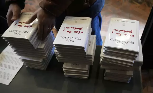 Copies of the book by Pope Francis titled "Viva la Poesia" (long live poetry) are set on a desk during its presentation to the journalists in Rome, Friday, March 21, 2025. (AP Photo/Gregorio Borgia)