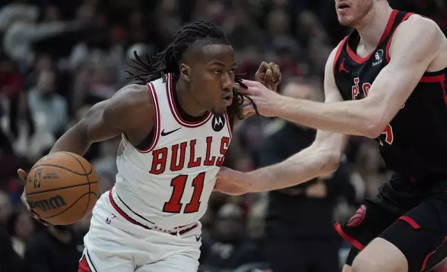 Chicago Bulls guard Ayo Dosunmu (11) handles the ball during the first half of an NBA basketball game against the Toronto Raptors, Friday, Feb. 28, 2025, in Chicago. (AP Photo/Erin Hooley)