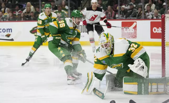 Minnesota Wild goaltender Filip Gustavsson (32) stops a shot during the second period of an NHL hockey game against the New Jersey Devils, Saturday, March 29, 2025, in St. Paul, Minn. (AP Photo/Abbie Parr)