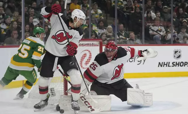 New Jersey Devils goaltender Jacob Markstrom (25) blocks a shot during the first period of an NHL hockey game against the Minnesota Wild, Saturday, March 29, 2025, in St. Paul, Minn. (AP Photo/Abbie Parr)