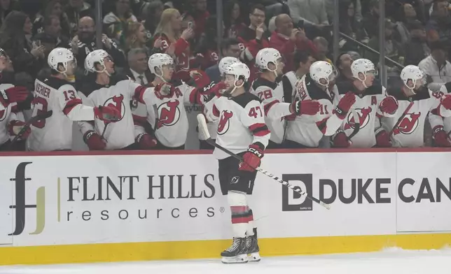 New Jersey Devils center Paul Cotter (47) celebrates with teammates after scoring during the first period of an NHL hockey game against the Minnesota Wild, Saturday, March 29, 2025, in St. Paul, Minn. (AP Photo/Abbie Parr)