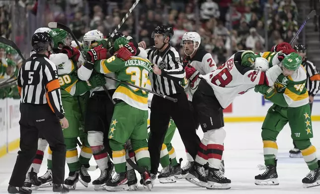 Minnesota Wild and New Jersey Devils players fight during the second period of an NHL hockey game, Saturday, March 29, 2025, in St. Paul, Minn. (AP Photo/Abbie Parr)