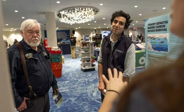 Adam Subhas, right, a scientist with the Woods Hole Oceanographic Institution looking to educate the fishing community on an ocean carbon project, speaks with marine engineer Paul Nosworthy, left, and Sarah Schumann, of the Fishery Friendly Climate Action Campaign, at the Massachusetts Lobstermen's Association Annual Weekend and Trade Show, Friday, Jan. 31, 2025, in Hyannis, Mass. (AP Photo/David Goldman)