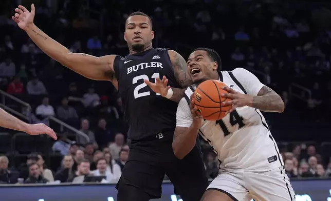 Providence's Corey Floyd Jr. (14) drives pastButler's Dante Maddox Jr. (21) during the first half of an NCAA college basketball game at the Big East basketball tournament Wednesday, March 12, 2025, in New York. (AP Photo/Frank Franklin II)