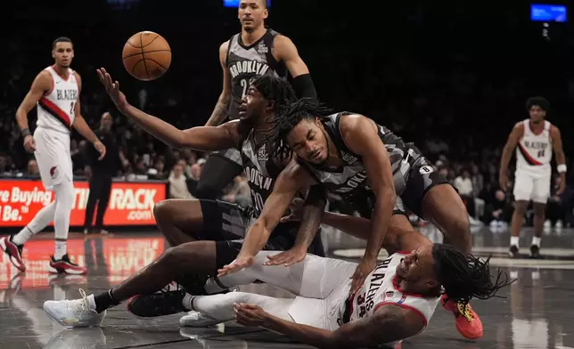 Portland Trail Blazers' Jabari Walker (34) fights for control of the ball with Brooklyn Nets' Day'Ron Sharpe (20) Cam Thomas (24) during the first half of an NBA basketball game Friday, Feb. 28, 2025, in New York. (AP Photo/Frank Franklin II)
