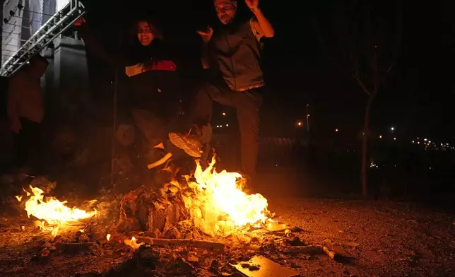 Iranians jump over a bonfire celebrating Chaharshanbe Souri, or Wednesday Feast, an ancient Festival of Fire on the eve of the last Wednesday of the Persian year, in Tehran, Iran, Tuesday, March 18, 2025. (AP Photo/Vahid Salemi)
