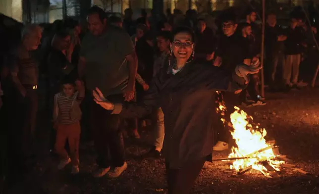 An Iranian woman dances while celebrating Chaharshanbe Souri, or Wednesday Feast, an ancient Festival of Fire on the eve of the last Wednesday of the Persian year, in Tehran, Iran, Tuesday, March 18, 2025. (AP Photo/Vahid Salemi)