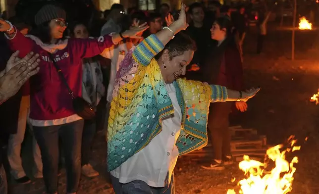 People dance while celebrating Chaharshanbe Souri, or Wednesday Feast, an ancient Festival of Fire on the eve of the last Wednesday of the Persian year, in Tehran, Iran, Tuesday, March 18, 2025. (AP Photo/Vahid Salemi)