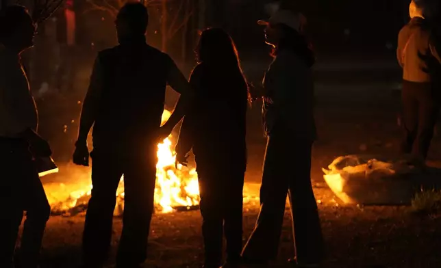 Iranians gather around a bonfire celebrating Chaharshanbe Souri, or Wednesday Feast, an ancient Festival of Fire on the eve of the last Wednesday of the Persian year, in Tehran, Iran, Tuesday, March 18, 2025. (AP Photo/Vahid Salemi)