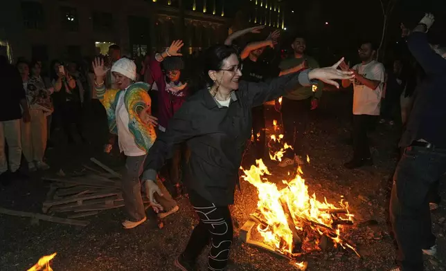 Iranians dance while celebrating Chaharshanbe Souri, or Wednesday Feast, an ancient Festival of Fire on the eve of the last Wednesday of the Persian year, in Tehran, Iran, Tuesday, March 18, 2025. (AP Photo/Vahid Salemi)