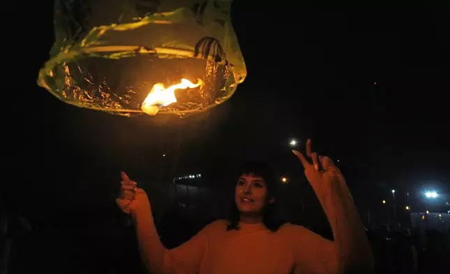 An Iranian woman releases a wishing lantern while celebrating Chaharshanbe Souri, or Wednesday Feast, an ancient Festival of Fire on the eve of the last Wednesday of the Persian year, in Tehran, Iran, Tuesday, March 18, 2025. (AP Photo/Vahid Salemi)