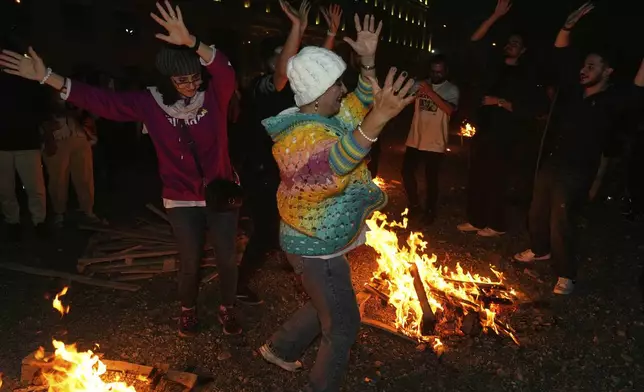 Iranians dance while celebrating Chaharshanbe Souri, or Wednesday Feast, an ancient Festival of Fire on the eve of the last Wednesday of the Persian year, in Tehran, Iran, Tuesday, March 18, 2025. (AP Photo/Vahid Salemi)
