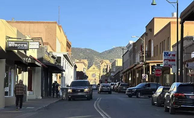 The sun begins to set as vehicles make their way through a historic district in downtown Santa Fe, New Mexico, on Thursday, Feb. 27, 2025. (AP Photo/Susan Montoya Bryan)