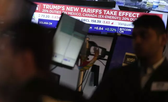 People work on the floor at the New York Stock Exchange in New York, Tuesday, March 4, 2025. (AP Photo/Seth Wenig)