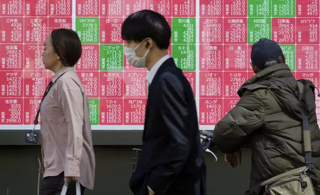 People walk in front of an electronic stock board showing Japan's Nikkei index at a securities firm Thursday, Feb. 27, 2025, in Tokyo. (AP Photo/Eugene Hoshiko)