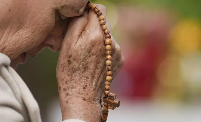 A woman prays for Pope Francis in front of the Agostino Gemelli Polyclinic, in Rome, Saturday, March 8, 2025, where the Pontiff is hospitalized since Feb. 14. (AP Photo/Andrew Medichini)