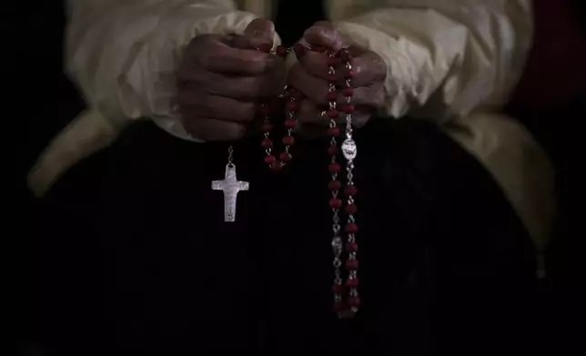 A Catholic woman attends a nightly rosary prayer service for the health of Pope Francis in St. Peter's Square at the Vatican, Wednesday, Feb. 26, 2025. (AP Photo/Bernat Armangue)