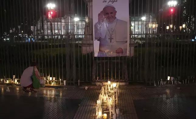 A person lights a candle for Pope Francis, who remains hospitalized in Rome, during a vigil in Buenos Aires, Argentina, Friday, March 7, 2025. (AP Photo/Rodrigo Abd)