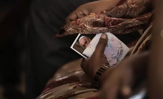 A Catholic holds a photograph of Pope Francis while offering prayers during a mass on Ash Wednesday at Santhome Cathedral Basilica in Chennai, India, Wednesday, March 5, 2025. (AP Photo/Mahesh Kumar A.)
