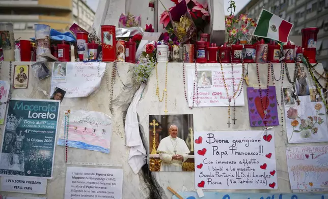 Candles and flowers are left for Pope Francis in front of the Agostino Gemelli Polyclinic, in Rome, Saturday, March 8, 2025, where the Pontiff is hospitalized since Feb. 14. (AP Photo/Andrew Medichini)