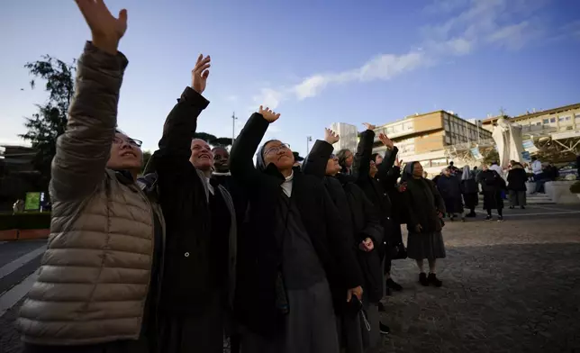 Nuns wave in front of the Agostino Gemelli Polyclinic, in Rome, Sunday, March 2, 2025, where Pope Francis has been hospitalized since Friday, Feb. 14. (AP Photo/Andrew Medichini)