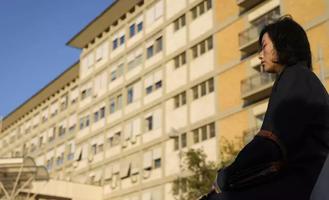 A woman prays outside the Agostino Gemelli Polyclinic where Pope Francis is hospitalized in Rome, Tuesday, March 4, 2025. (AP Photo/Gregorio Borgia)