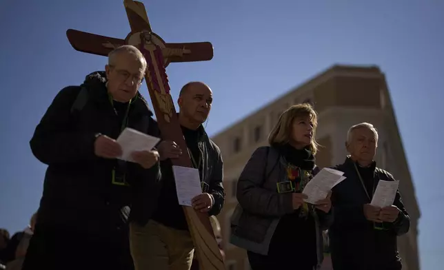 Christian Catholic worshippers pray as they walk towards St. Peter's Square, in Rome, Italy, Thursday, March 6, 2025. (AP Photo/Francisco Seco)