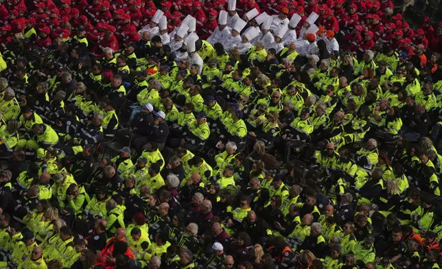 Members of different organizations of volunteers follow Cardinal Michael Czerny, delegate of Pope Francis who is being treated for pneumonia at Rome's Agostino Gemelli Polyclinic, celebrating a mass for the world of volunteers in St. Peter's Square at The Vatican, Sunday, March 9, 2025. (AP Photo/Francisco Seco)