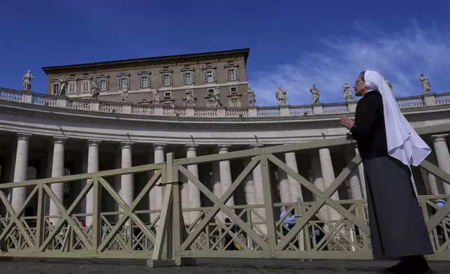 A nun prays towards the window at the Vatican at the time when Pope Francis would usually bestow his blessing, the Pontiff is currently recovering from a bilateral pneumonia at Rome's Agostino Gemelli Polyclinic, in Rome, Sunday, March 2, 2025. (AP Photo/Kirsty Wigglesworth)