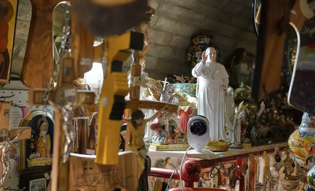 A statue of Pope Francis sits among other religious items at a shop in Assisi, Italy, Saturday, March 1, 2025. (AP Photo/Gregorio Borgia)